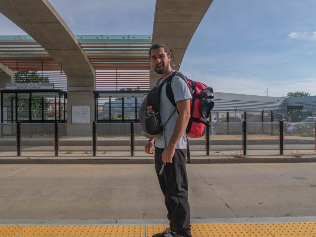 Photo of myself standing with my bags at the Box District Silver Line Bus station in outside of Boston. 