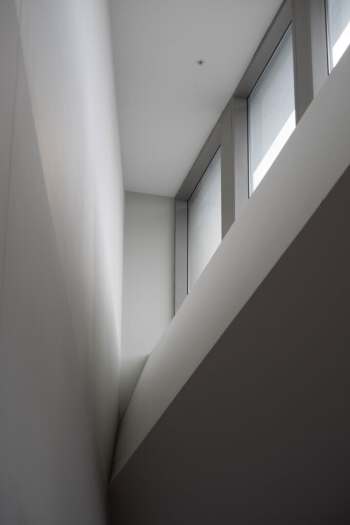 A self proclaimed artistic picture of three windows letting in light to the corner of my airport terminal.