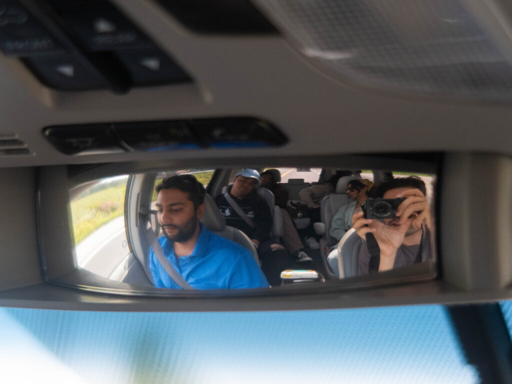 Image of fish eye mirror showing all passengers in a minivan. 